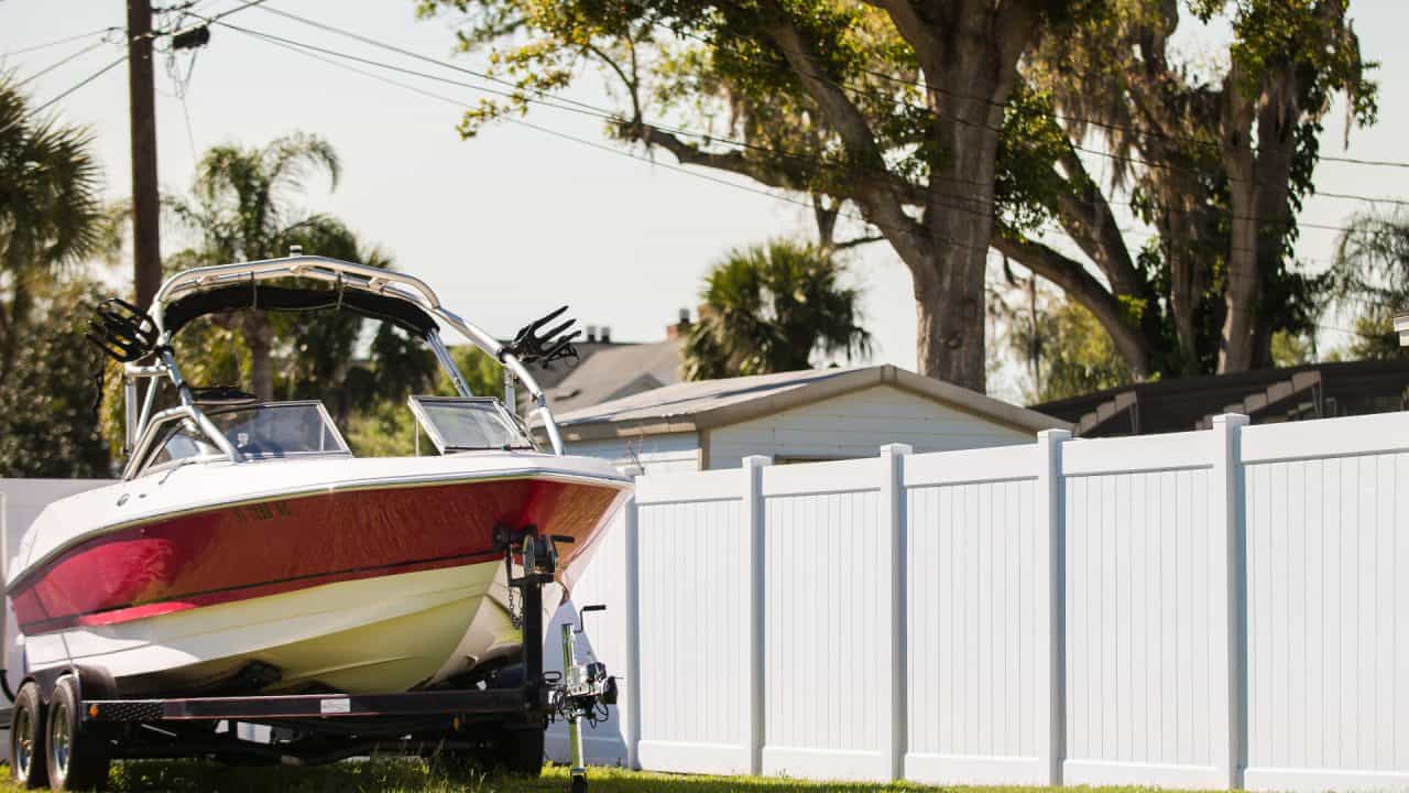 fence company near me Columbia white vinyl fence and a boat in the yard