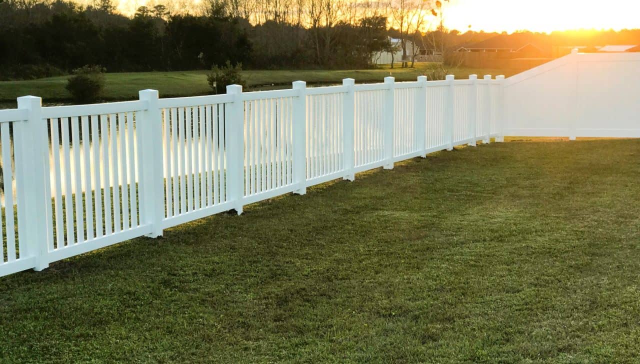 White Fence in yard behind sunset