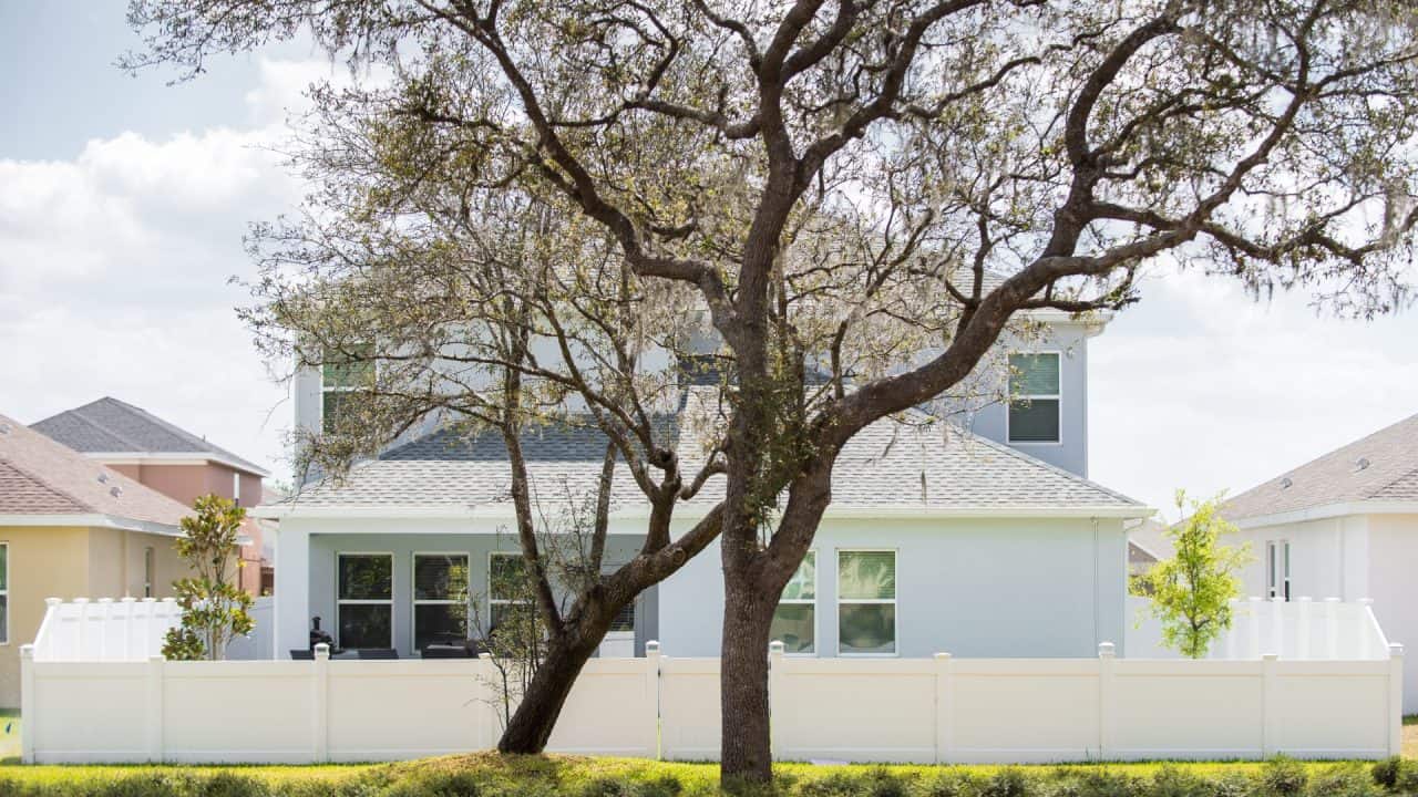 Vinyl Fence with a house and tree